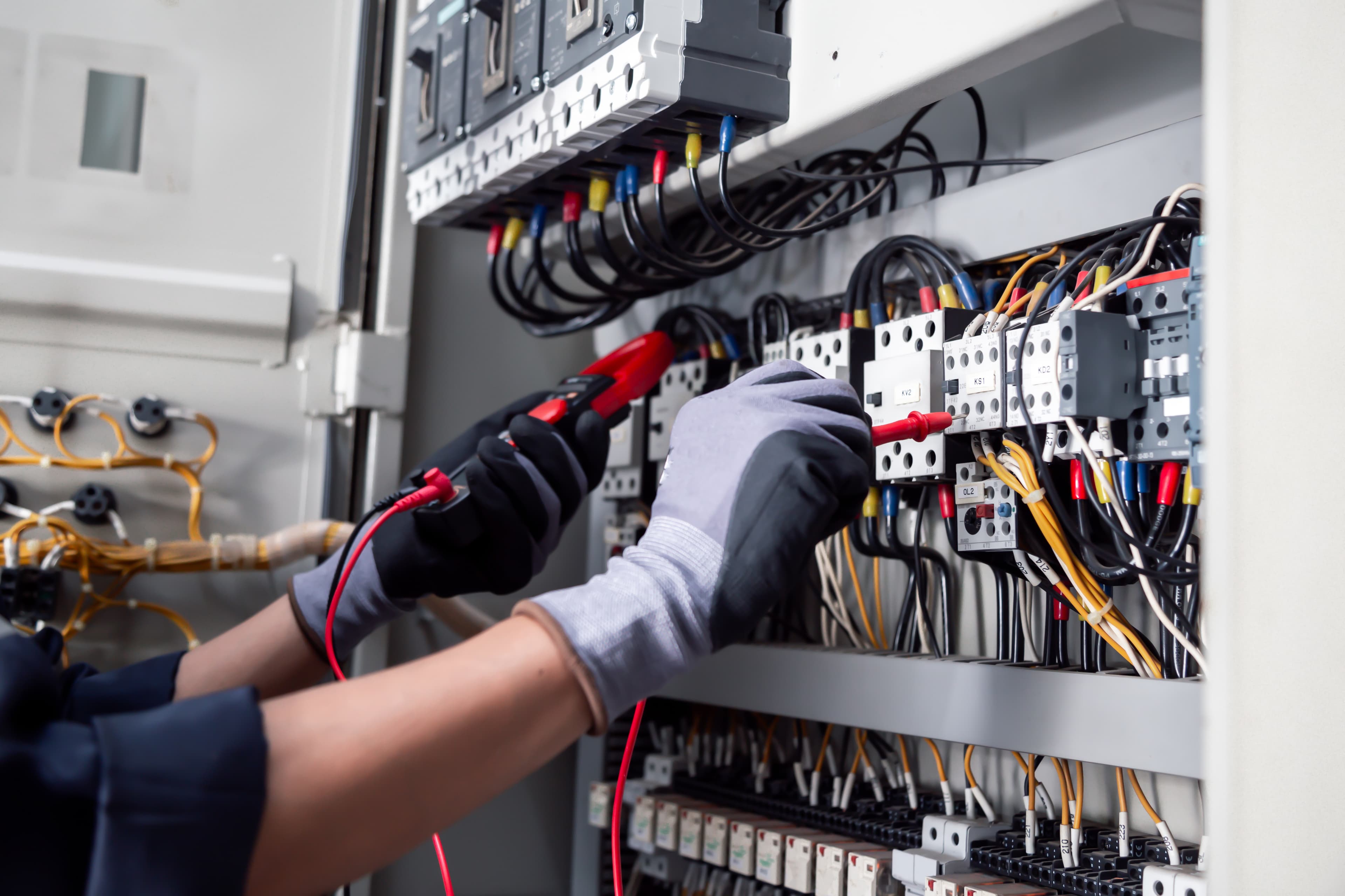 Elektriker bei Fehlerdiagnose mit Messgerät an elektrischer Anlage