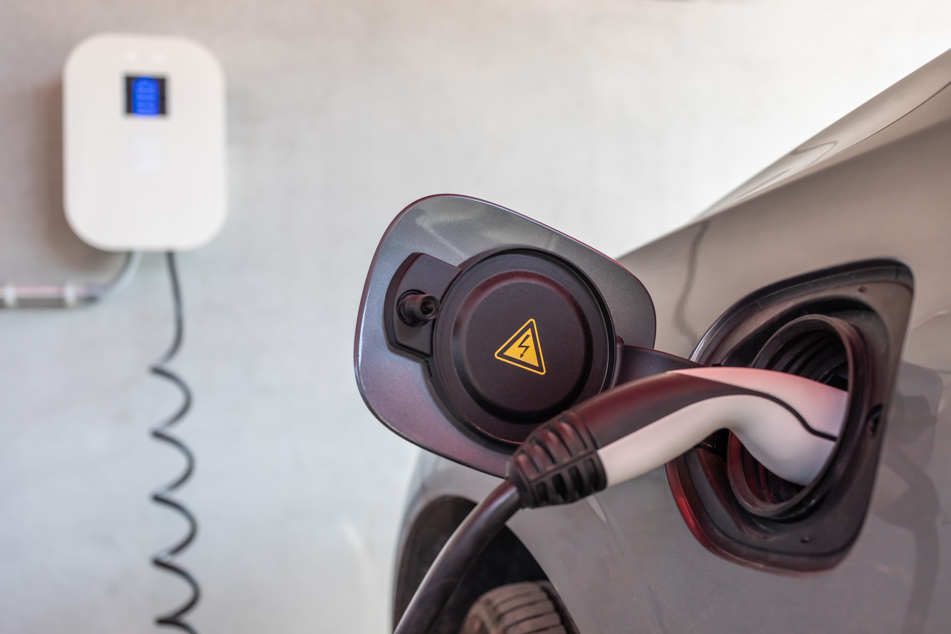 Wallbox Ladestation an Garage mit angeschlossenem Elektroauto